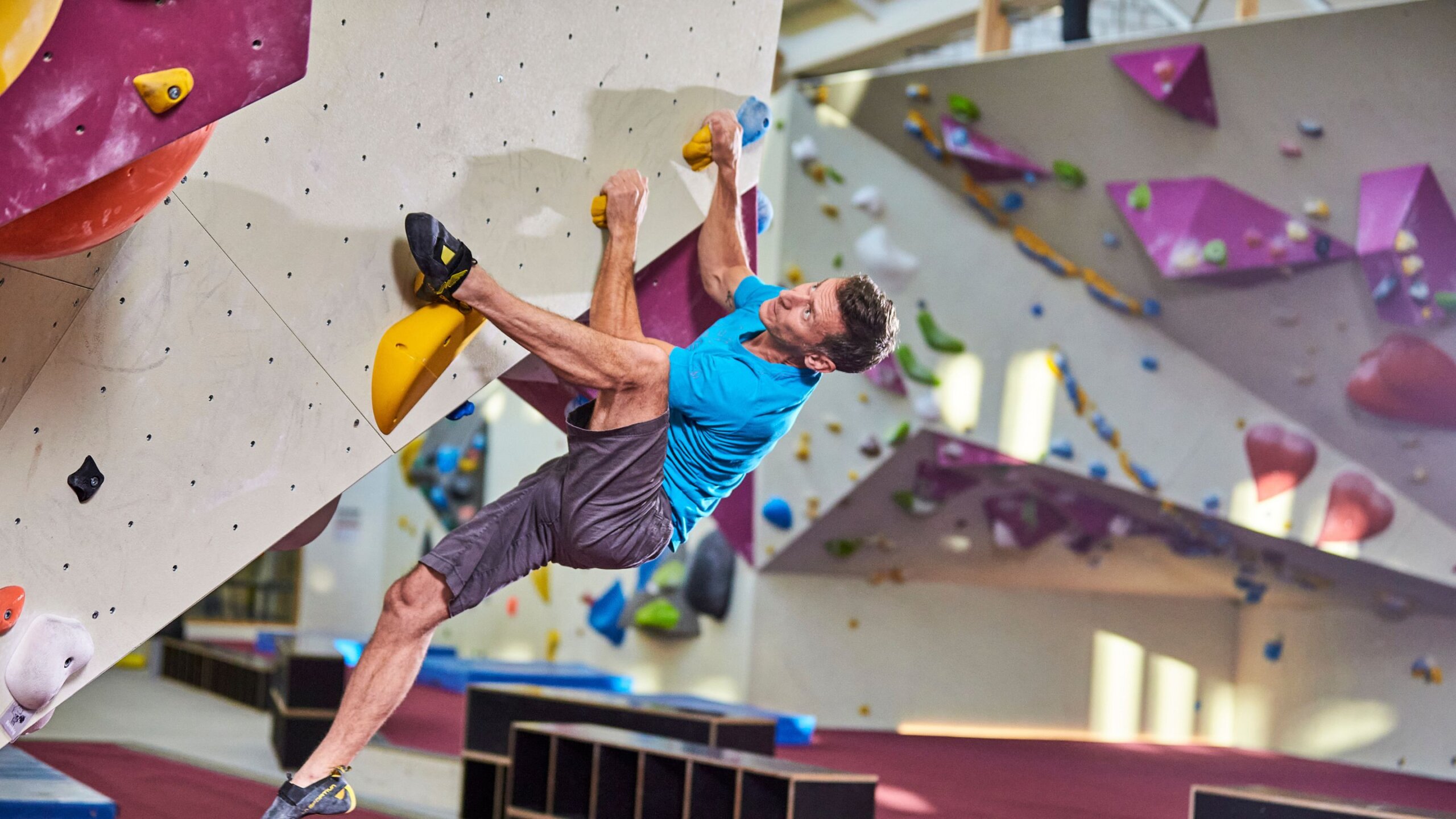 Boulderer klettert eine Boulderwand hoch